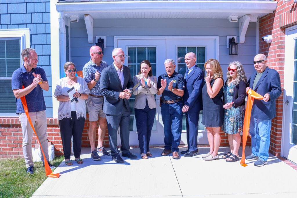 Pillar Care stakeholders clap as the ribbon falls at the affordable housing complex